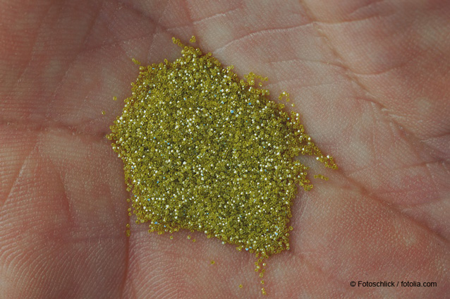 Small cluster of yellow gold colored industrial diamonds in the center of a human hand